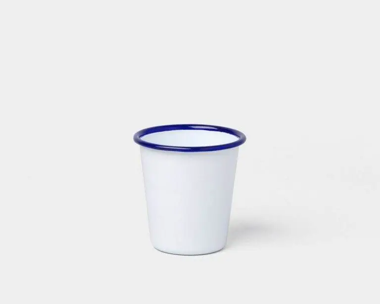 A white Falcon Enamelware cup on a white surface.