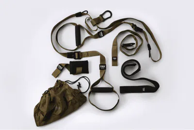 A TRX suspension training system with straps and a bag on a white surface.