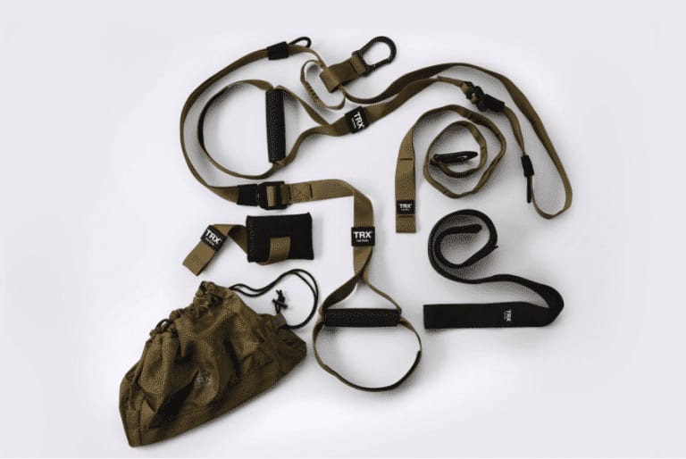 A TRX suspension training system with straps and a bag on a white surface.
